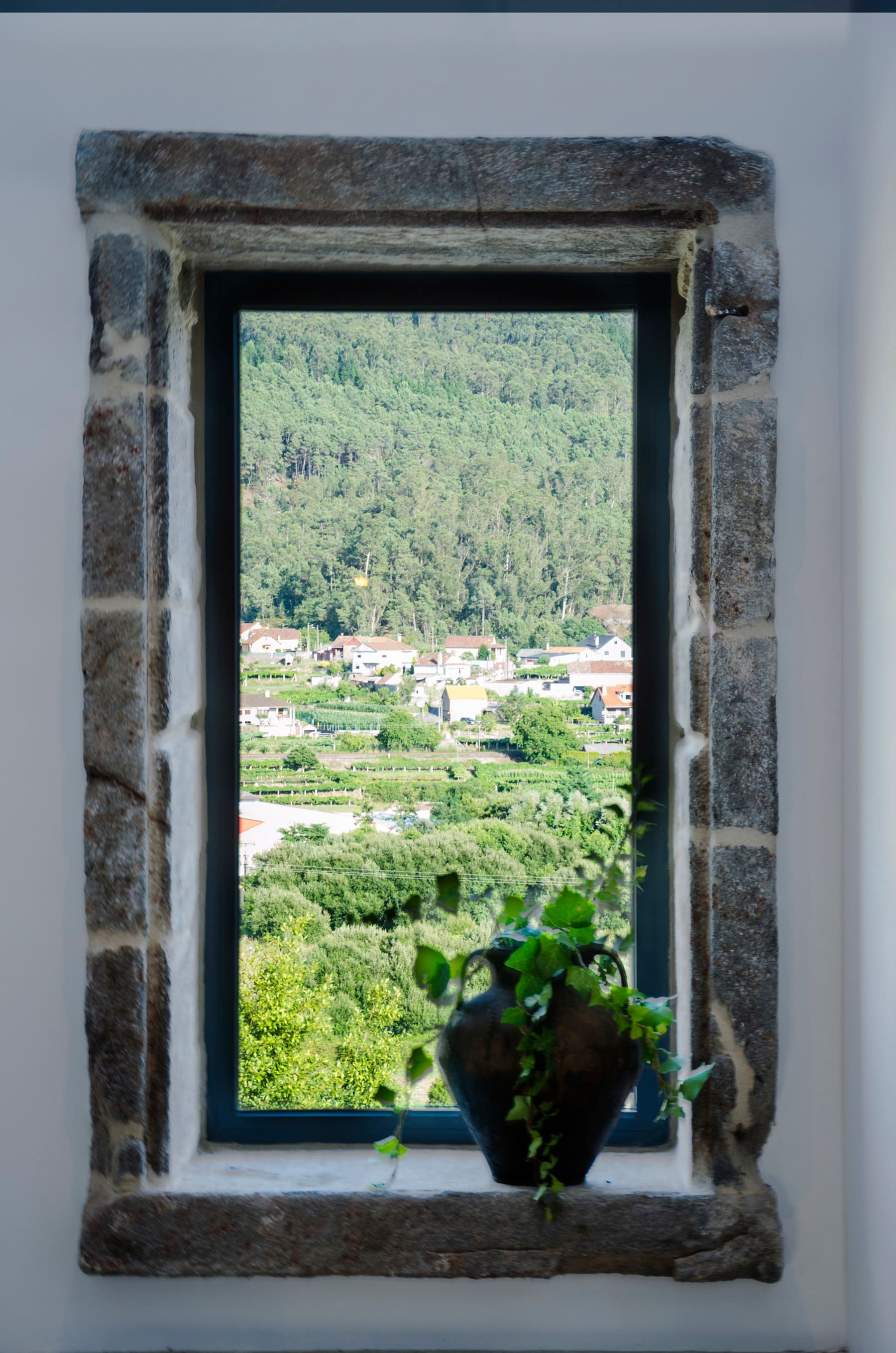 El valle de Mos visto desde el hueco de piedra de una ventana de Casa dos Parladoiros.